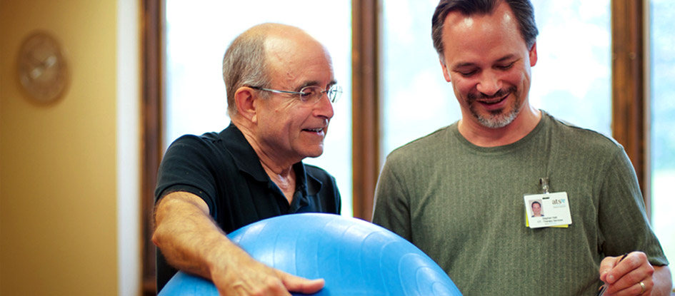 therapist and resident with exercise ball