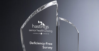 Glass award engraved with the Hastings Senior Health & Living logo and the words “Deficiency-Free Survey.”